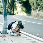 人の話を奪う人と、会話的ナルシシズム Young boy crouching on a sidewalk, inspecting something. Outdoor city environment.