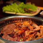 Close-up of grilled shrimp, sausages, and meat on a barbecue grill, perfect for a gourmet meal.